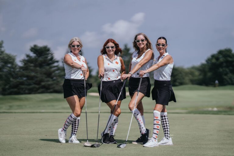 Four golfers in argyle socks posing with their clubs